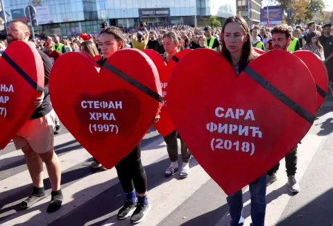 epa12496902 The names of the victims are displayed on oversized heart cut-outs as people observe 16 minutes of silences as they pay respect to the victims in front of the Novi Sad train station during the commemoration in Novi Sad, Serbia, 01 November 2025. The student-led event marks the first anniversary of the railway station canopy collapse that killed 16 people, sparking widespread protests demanding political accountability. EPA/ANDREJ CUKIC