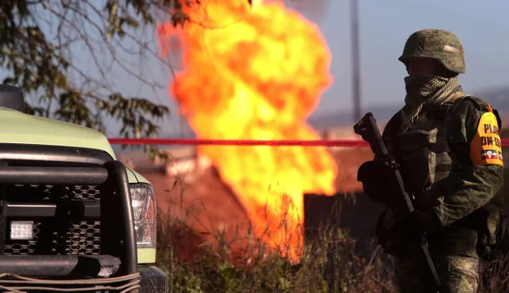 epa06897197 Members of the Mexican Army guard the area near a pipeline fire in the municipality of Acajete, Puebla, Mexico, 18 July 2018. An illegal tapping of a pipeline of Petroleos Mexicanos (Pemex) caused a fire that has not been extinguished in the state of Puebla and no injuries were reported, according to Pemex. EPA/Hilda RA&shy;os