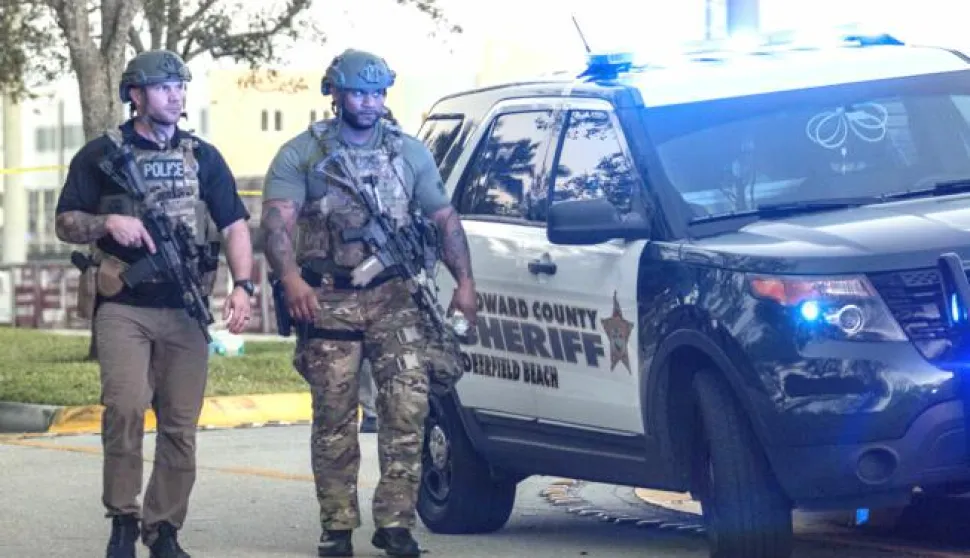 epa06525856 Two SWAT officers walk in front of the side entrance of the Marjory Stoneman Douglas High School after a shooting in Parkland, Florida, USA, 14 February 2018. Multiple fatalities have been reported and several more injured at a high school northwest of Miami. According to law enforcement the suspect is in custody. Some media are reporting the suspect as former student, Nicolas Cruz. EPA/CRISTOBAL HERRERA