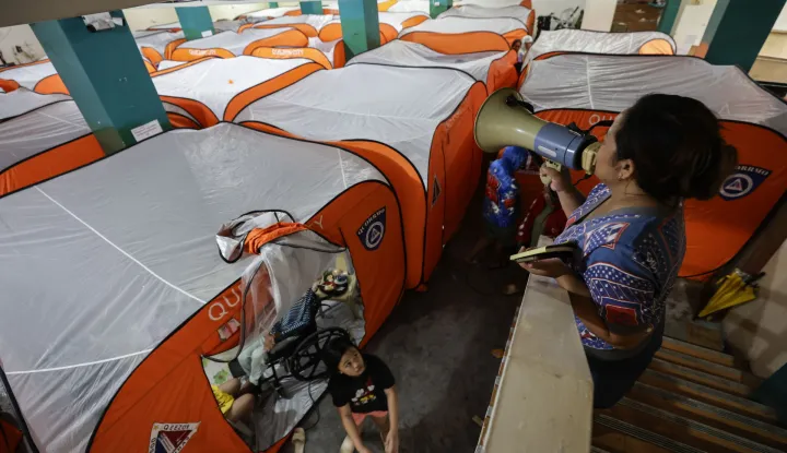 epa12513651 A village assistance personnel makes an announcement at an evacuation center set up in anticipation of Typhoon Fung-Wong in Quezon City, Metro Manila, Philippines, 09 November 2025. According to the Philippine Atmospheric, Geophysical, and Astronomical Services Administration (PAGASA), the typhoon is projected to be 100 kilometers northeast of Daet, Camarines Norte in the Bicol region, moving west-northwest at 30 kilometers per hour with maximum winds of 185 kilometers per hour. EPA/ROLEX DELA PENA