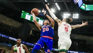 epa07250944 New York Knicks forward Kevin Knox (C) shoots between Milwaukee Bucks forward D.J. Wilson (R) and Milwaukee Bucks forward Khris Middleton (L) during the NBA game between the New York Knicks and the Milwaukee Bucks at Fiserv Forum in Milwaukee, Wisconsin, USA, 27 December 2018. EPA/TANNEN MAURY SHUTTERSTOCK OUT