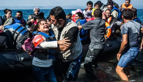 epa12347921 (FILE) - Migrants reach the shore in an overloaded rubber dinghy as they arrive on the coast near Skala Sikaminias, Lesbos island, Greece, 03 October 2015 (reissued 03 September 2025). The 2015 European migrant crisis refers to a large-scale arrival of refugees and migrants, especially from the Middle East, to Europe. The crisis reached a peak in terms of public visibility, humanitarian challenges and political responses early September: 1 September, thousands of refugees were stranded at the Budapest's Keleti railway station; 2 September, the photo of two-years old Alan Kurdi washed up on a Turkish beach became a powerful symbol of the crisis; 05 September, Germany and Austria jointly allowed refuges to cross their borders and apply for asylum. Angela Merkel's decision to allow refugees into Germany marked a significant turning point, temporarily waiving the European Dublin Regulation. Her famous statement, "We can do this" (Wir schaffen das), is directly tied to this moment. EPA/FILIP SINGER *** Local Caption *** 52289943
