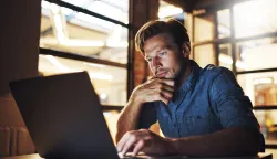 Laptop, thinking and business man reading email for project, research and deadline at night. Computer, creative and web designer problem solving or planning solution for software update in startup