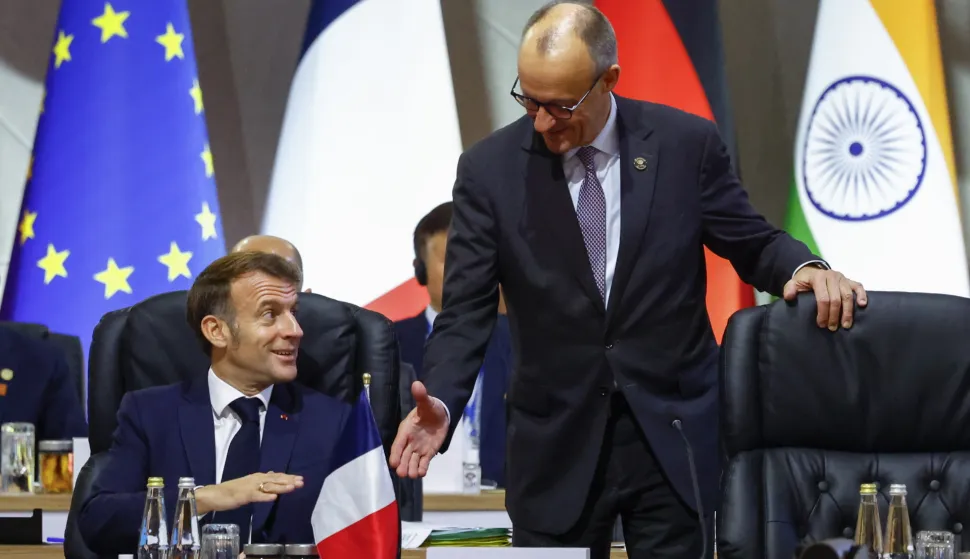 epa12541363 France's President Emmanuel Macron reacts as he speaks with German Chancellor Friedrich Merz at a plenary session on the opening day of the G20 Summit at the Nasrec Expo Centre in Johannesburg, South Africa, 22 November 2025. World leaders are gathering in South Africa, the host of this year's G20 Leaders' Summit on 22 and 23 November 2025, to discuss the global economy, development and financing. EPA/THOMAS MUKOYA/POOL
