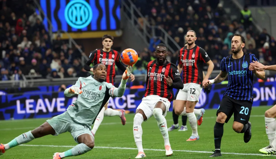 epa12544875 AC Milan?s goalkeeper Mike Maignan (L) in action after saving a penalty kicked by Inter Milan?s Hakan Calhanoglu (R) during the Italian Serie A soccer match between Inter and Milan at Giuseppe Meazza stadium in Milan, Italy, 23 November 2025. EPA/MATTEO BAZZI