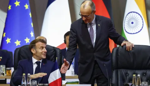 epa12541363 France's President Emmanuel Macron reacts as he speaks with German Chancellor Friedrich Merz at a plenary session on the opening day of the G20 Summit at the Nasrec Expo Centre in Johannesburg, South Africa, 22 November 2025. World leaders are gathering in South Africa, the host of this year's G20 Leaders' Summit on 22 and 23 November 2025, to discuss the global economy, development and financing. EPA/THOMAS MUKOYA/POOL