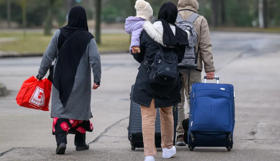 dpatop - 13 March 2025, Brandenburg, Eisenh?ttenstadt: Migrants leave the premises of Brandenburg's Central Immigration Office (ZABH) with luggage. Brandenburg is taking a new approach to speeding up the return of asylum seekers to Poland. A new so-called "Dublin Center" for the faster return of asylum seekers to other EU states is starting work. The aim is to speed up the organization of transfers to Poland. This involves so-called Dublin cases, i.e. people who have to go through their asylum procedure in another EU country. Photo: Patrick Pleul/dpa Photo: Patrick Pleul/DPA