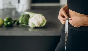 Young woman with measuting tape on weist at the kitchenmrsavljenje debljina vjezba freepik