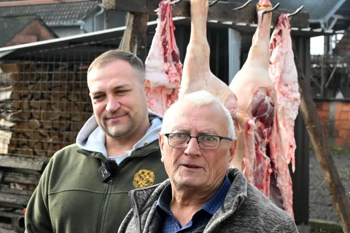 Stari Mikanovci, 08.12.2025. - Potpredsjednik Vlade i ministar poljoprivrede, šumarstva i ribarstva David Vlajčić u ponedjeljak, 8. prosinca 2025. godine sudjelovao je u tradicionalnoj svinjokolji kod Marka Ljubasa u Starim Mikanovcima (kod Vinkovaca). Na fotgrafiji Marko Ljubas i David Vlajčić. foto HINA/ Gordan Panić/ tm