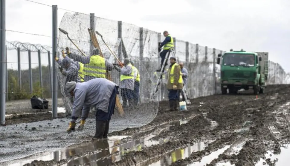 epa05606793 Hungarian convicts install an experimental section of the second line of the border fence at the Hungarian-Serbian border near the village of Gara, 213 kms south of Budapest, Hungary 28 October 2016. The 10.3 kilometer long section is constructed between Gara and Bacsszentgyorgy to reinforce the primary fence that prevents illegal migrants using the Balkan route from entering Hungary. EPA/SANDOR UJVARI HUNGARY OUT