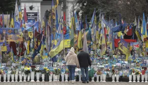 epa12594169 People walk next to a makeshift memorial dedicated to the fallen Ukrainian soldiers and international volunteers in Independence Square in Kyiv, Ukraine, 15 December 2025, amid the Russian invasion. EPA/SERGEY DOLZHENKO