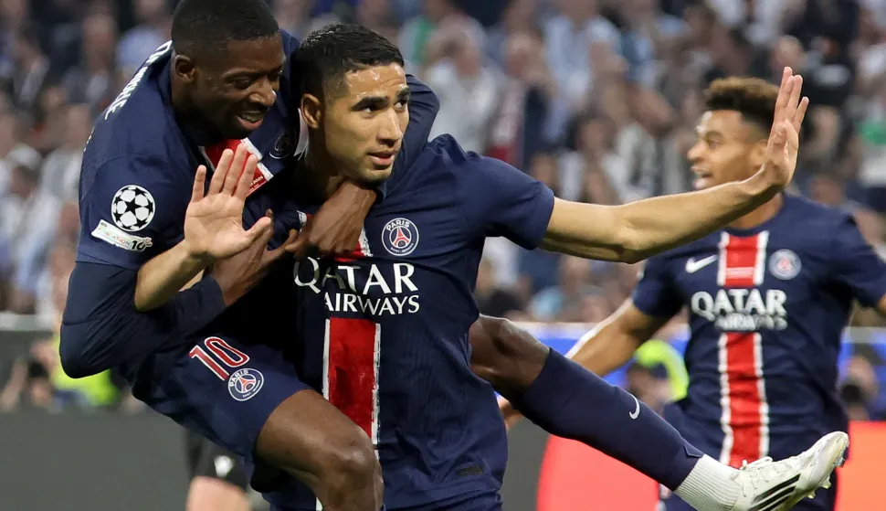 epa12147884 Achraf Hakimi (C) of PSG celebrates with teammate Ousmane Dembele after scoring the opening goal during the UEFA Champions League final between Paris Saint-Germain and Internazionale Milano in Munich, Germany 31 May 2025. EPA/RONALD WITTEK