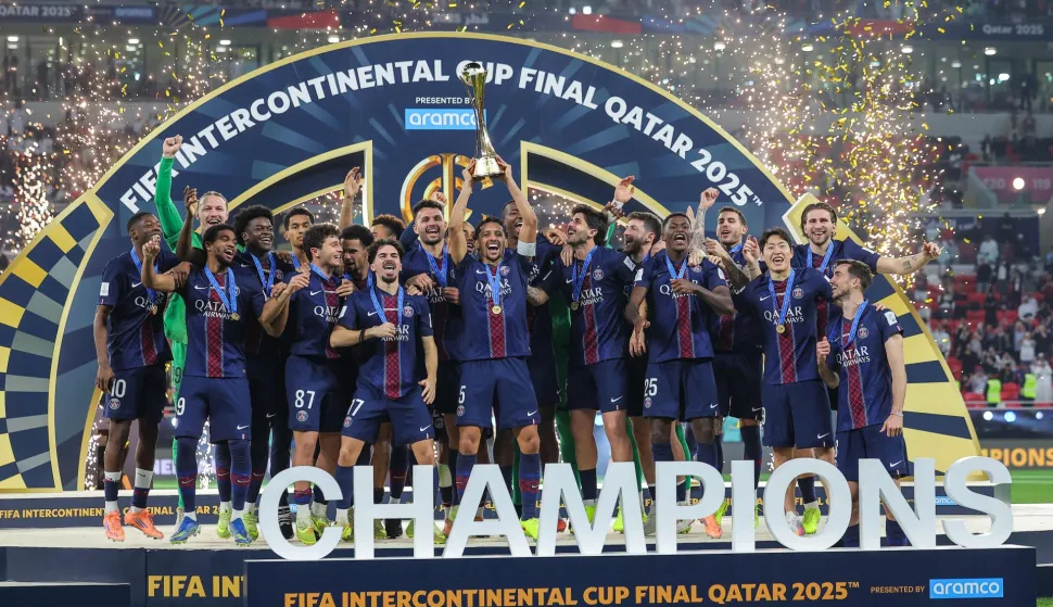 TOPSHOT - PSG's players celebrate on the podium after winning the 2025 FIFA Intercontinental Cup final football match between Paris Saint-Germain (PSG) and CR Flamengo at the Ahmad bin Ali Stadium in Al-Rayyan on the outskirts of Doha on December 17, 2025. (Photo by Karim JAAFAR/AFP)