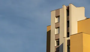 A vertical low angle shot of a concrete white and brown modern building under the cloudy skyzgrada stanovi stanogradnja ilustracija freepik