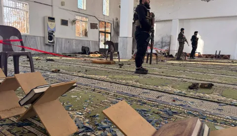 TOPSHOT - Armed men stand inside the Imam Ali ibn Abi Talib Mosque following an explosion in the Wadi al-Dahab neighborhood of Homs on December 26, 2025. A deadly explosion hit a mosque in a predominantly Alawite area of Syria's Homs on December 26, said authorities who reported at least six people killed. "A terrorist explosion targeted the Ali Bin Abi Talib Mosque during Friday prayers in Al-Khadri Street in the Wadi al-Dahab neighbourhood of Homs," the interior ministry said in a statement, adding that six people were killed and 21 others wounded. (Photo by Omar HAJ KADOUR/AFP)