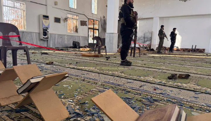 TOPSHOT - Armed men stand inside the Imam Ali ibn Abi Talib Mosque following an explosion in the Wadi al-Dahab neighborhood of Homs on December 26, 2025. A deadly explosion hit a mosque in a predominantly Alawite area of Syria's Homs on December 26, said authorities who reported at least six people killed. "A terrorist explosion targeted the Ali Bin Abi Talib Mosque during Friday prayers in Al-Khadri Street in the Wadi al-Dahab neighbourhood of Homs," the interior ministry said in a statement, adding that six people were killed and 21 others wounded. (Photo by Omar HAJ KADOUR/AFP)