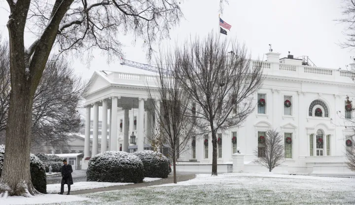 epa12572462 A person walks as a light snow falls on the White House in Washington, DC, USA, 05 December 2025. The capital city's first snow of the season is not expected to accumulate more than one inch. EPA/JIM LO SCALZO
