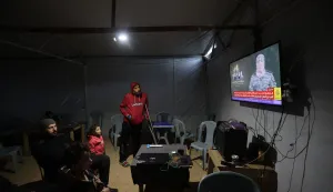 Displaced Palestinians follow the press conference of a new spokesperson for the Ezzedine Al-Qassam Brigades, in Bureij refugee camp Central of Gaza Strip on December 29, 2025. Hamas' armed wing confirmed on December 29 the death of its spokesperson, Abu Obeida, months after Israel announced that he had been killed in an air strike in Gaza. Ezzedine Al-Qassam Brigades released a video statement on its Telegram channel, saying: "We pause in reverance before, the masked man loved by millions, the great martyred commander and spokesperson of the Qassam Brigades, Abu Obeida". Israel had announced it had killed Abu Obeida in a strike on Gaza on August 30. (Photo by Eyad Baba/AFP)