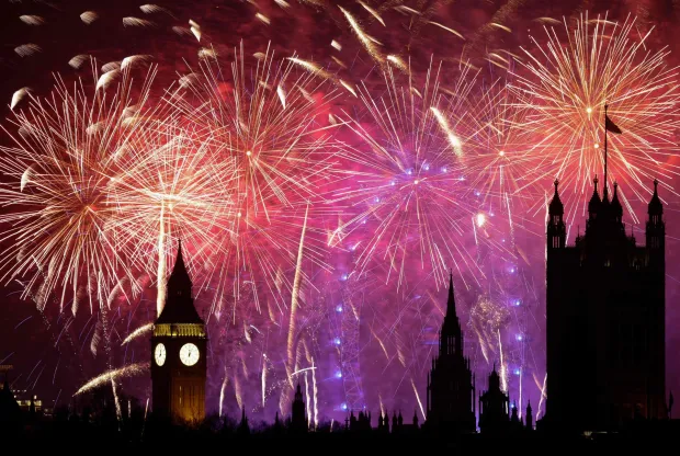 Fireworks explode in the sky to bring in the New Year around the London Eye and the Elizabeth Tower, commonly known by the name of the clock's bell "Big Ben", at the Palace of Westminster, home to the Houses of Parliament, in central London at midnight on January 1, 2026. (Photo by Brook Mitchell/AFP)