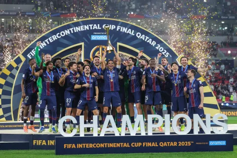 TOPSHOT - PSG's players celebrate on the podium after winning the 2025 FIFA Intercontinental Cup final football match between Paris Saint-Germain (PSG) and CR Flamengo at the Ahmad bin Ali Stadium in Al-Rayyan on the outskirts of Doha on December 17, 2025. (Photo by Karim JAAFAR/AFP)