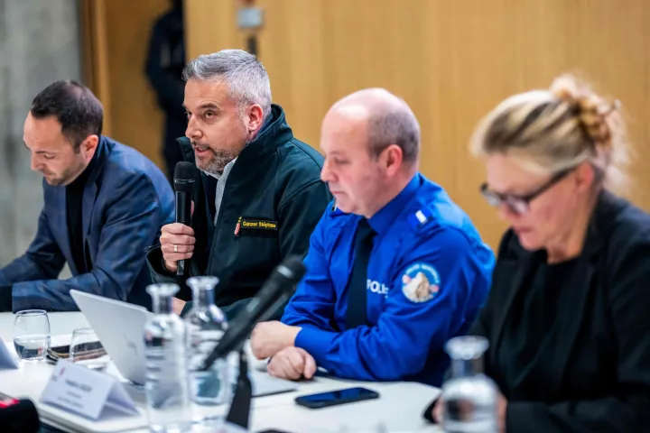 Head of the Department of Security Stephane Ganzer (2nd L) reacts as he speaks during a press conference following an explosion that ripped through the bar Le Constellation in the luxury Alpine ski resort town of Crans-Montana, on January 1, 2026. "Several dozen" people are believed to have died and around 100 were injured when a fire ripped through a crowded bar in the luxury Swiss ski resort town of Crans-Montana, police said January 1. (Photo by MAXIME SCHMID/AFP)
