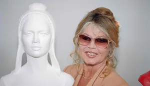 (FILES) French actress Brigitte Bardot smiles next to the bust of Marianne, the symbol of the French Republic, for which Bardot served as a model, in Paris, on May 11, 1993. Brigitte Bardot, legendary French actress, female icon of the 1960s and fervent animal rights activist, has died at the age of 91, the Brigitte Bardot Foundation announced on December 28, 2025. (Photo by Vincent AMALVY/AFP)