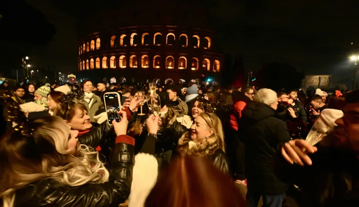 People gather during New Year's celebrations in front of the Colosseum in central Rome on December 31, 2025. (Photo by Filippo MONTEFORTE/AFP)