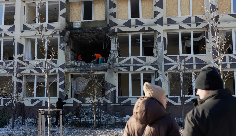 People clear debris in a damaged private medical clinic following a drone strike in Kyiv, on January 5, 2026, amid the Russian invasion in Ukraine. (Photo by Tetiana DZHAFAROVA/AFP)