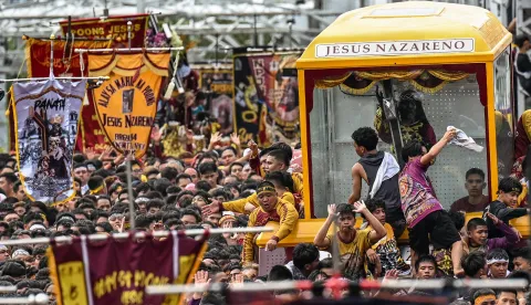 Catholic devotees join along with the carriage carrying the image of Jesus Nazareno, also known as Jesus the Nazarene, during the annual religious procession in Manila on January 9, 2026. Tens of thousands of Philippine Catholics twirled white cloths and chanted "Viva, viva" as a historic statue of Jesus Christ was paraded through the streets of Manila on January 9 in the nation's biggest annual religious event. (Photo by Jam STA ROSA/AFP)