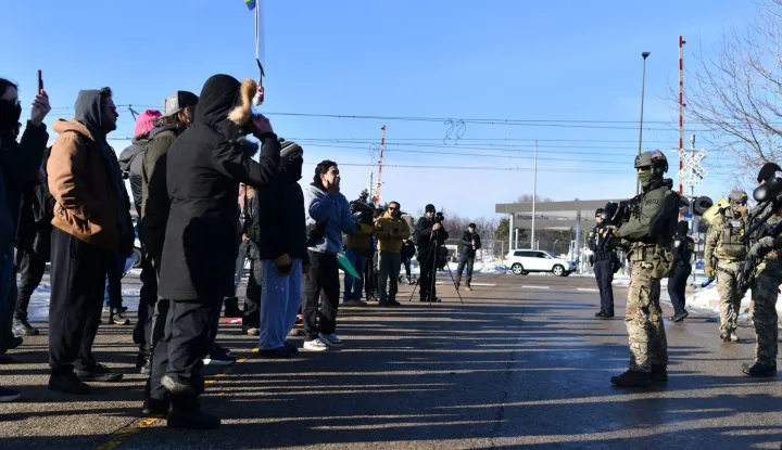 Federal law enforcement agents face protesters outside the Bishop Henry Whipple Federal Building during a demonstration over the fatal shooting of Renee Good by a US Immigration and Customs Enforcement (ICE) agent, in Minneapolis, Minnesota, on January 9, 2026. A US Immigration and Customs Enforcement (ICE) agent shot and killed an American woman on the streets of Minneapolis January 7, leading to huge protests and outrage from local leaders who rejected White House claims she was a domestic terrorist. The woman, identified in local media as 37-year-old Renee Nicole Good, was hit at point blank range as she apparently tried to drive away from agents who were crowding around her car, which they said was blocking their way. (Photo by Octavio JONES/AFP)