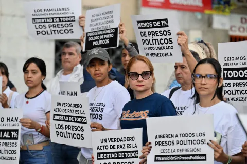 Relatives of political prisoners demonstrate in demand of the release of their loved ones, near the notorious El Helicoide -a facility and prison owned by the Venezuelan government and used for both regular and political prisoners of the Bolivarian National Intelligence Service (SEBIN)- in Caracas on January 9, 2026. Venezuela began releasing a "large number" of political prisoners, including several foreigners, in a move praised by US President Donald Trump on January 9 as a step toward cooperation after the ouster of ruler Nicolas Maduro. (Photo by Juan BARRETO/AFP)