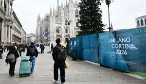 People walk past Milano Cortina 2026 Winter Olympic Games banners in Duomo's square in Milan on Januray 9, 2026. (Photo by Stefano RELLANDINI/AFP)