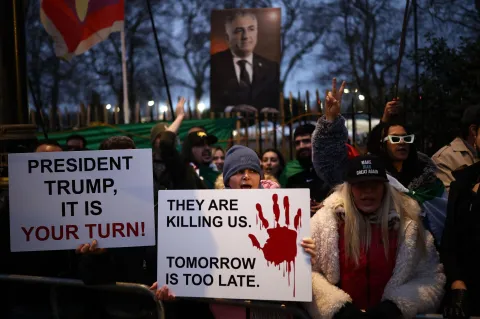 Anti-Iranian regime protesters wave Iranian flags during a gathering outside the Iranian Embassy, central London, on January 12, 2026. (Photo by Henry NICHOLLS/AFP)