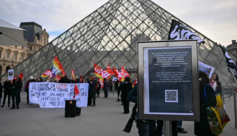 (FILES) A notice informs members of the public of the closure of the Louvre Museum as members of the French CGT union protest outside the entrance as museum workers voted to go on strike against increasingly deteriorating working conditions and the declining visitor experience at the world famous museum, in Paris on December 15, 2025. The Louvre museum was forced to close on January 12, 2026 after its staff, who have been on strike since mid-December in a bid to secure better working conditions, decided to continue their action, AFP learned from the museum and trade unions. (Photo by Blanca CRUZ/AFP)
