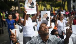 An Evangelical man prays during an event in support of deposed Venezuelan president Nicolas Maduro and his wife Cilia Flores, at Plaza Bolivar in Caracas on January 11, 2026. (Photo by Federico PARRA/AFP)