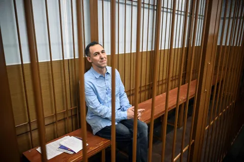 (FILES) Laurent Vinatier, a French researcher accused of gathering Russian military information without registering as a "foreign agent", sits inside a defendants' cage during a hearing in Moscow's Zamoskvoretsky district court on October 14, 2024. Moscow has made an offer to France regarding jailed researcher Laurent Vinatier, facing espionage charges that could see him sentenced to 20 years in a Russian prison, the Kremlin said on December 25, 2025. (Photo by Alexander NEMENOV/AFP)