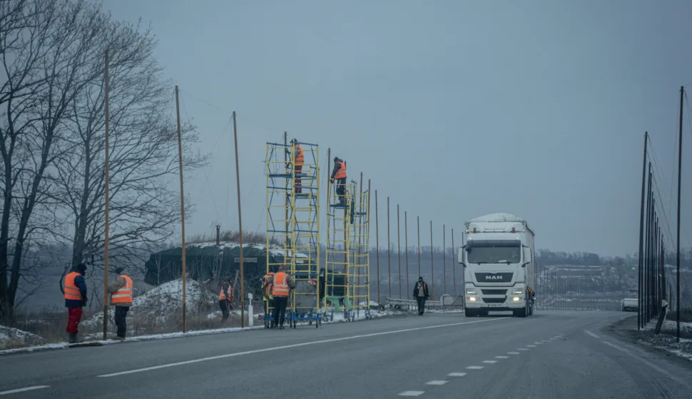 Municipal service workers hang anti-drone nets on the Kharkiv ring road, which runs along the Russian border in Kharkiv, on January 10, 2026, amid the Russian invasion of Ukraine. (Photo by Ivan SAMOILOV/AFP)