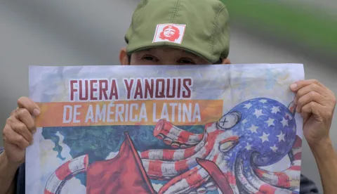 A man holds a banner against US President Donald Trump during a march against imperialism and intervention in Venezuela, in Cali, Colombia on January 15, 2026. Colombian President Gustavo Petro announced that he will meet in the United States with his counterpart Donald Trump on February 3, amid a de-escalation of diplomatic tensions between the two leaders. (Photo by JOAQUIN SARMIENTO/AFP)