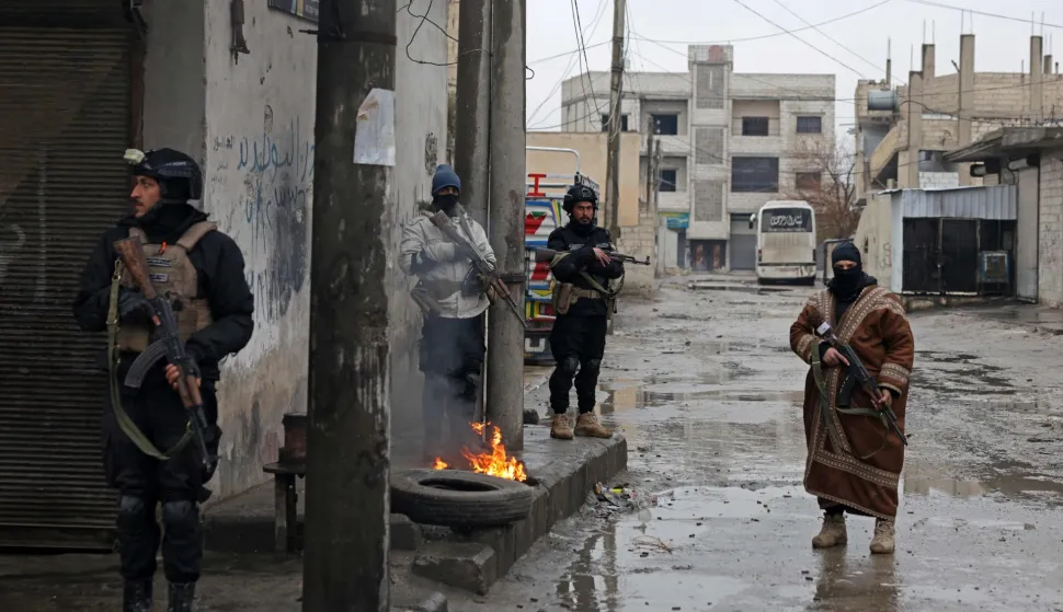 Syrian army personnel stand guard next to a burning tyre along a street in Tabqa, in Raqa province, on the southwestern banks of the Euphrates on January 18, 2026. Kurdish-led forces withdrew on January 18 from Syria's largest oil field, a conflict monitor said, as government troops extended their grip over swathes of territory in the country's north and east. Government troops drove Kurdish forces from two Aleppo neighbourhoods following clashes last week, and on January 17 announced they had captured an area east of the city, as well as Tabqa. (Photo by Bakr ALkasem/AFP)