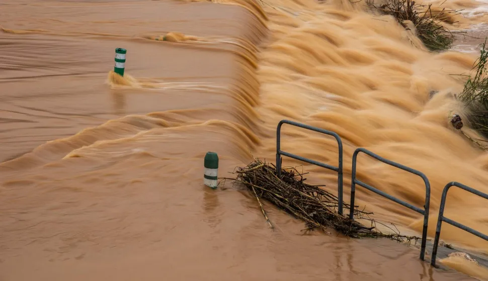 This photograph shows the overflowing of the Agly river flooding a road at the entrance of Rivesaltes in the Pyrenees-Orientales department in south-western France on December 26, 2025. Aude, Pyr?n?es-Orientales and Haute-Corse have been placed on orange alert for rain?flooding or floods by M?t?o-France until midnight on December 26, 2025. (Photo by Jean-Christophe MILHET/AFP)