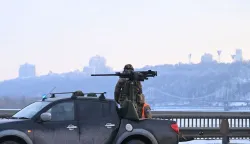 A Ukrainian serviceman stands next to a truck equipped with a machine gun during an air raid alert in Kyiv on January 24, 2026, amid the Russian invasion of Ukraine. (Photo by Sergei GAPON/AFP)