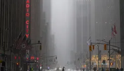 A man walks across Sixth Avenue as snow falls in the Manhattan borough of New York City on January 25, 2026. A massive winter storm on January 24 dumped snow and freezing rain from New Mexico to North Carolina as it swept across the United States towards the northeast, threatening tens of millions of Americans with blackouts, transportation chaos and bone-chilling cold. After battering the country's southwest and central areas, the storm system began to hit the heavily populated mid-Atlantic and northeastern states as a frigid air mass settled in across the nation. (Photo by CHARLY TRIBALLEAU/AFP)
