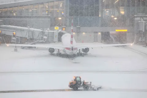 TOPSHOT - A snow removal machine is seen working on the tarmac of LaGuardia airport in New York on January 25, 2026. A massive winter storm on January 24, 2026 dumped snow and freezing rain on New Mexico and Texas as it swept across the United States towards the northeast, threatening tens of millions of Americans with blackouts, transportation chaos and bone-chilling cold. Shoppers stripped supermarket shelves as the National Weather Service (NWS) forecast huge snowfall in some areas and possibly "catastrophic" ice accumulations. (Photo by CHARLY TRIBALLEAU/AFP)