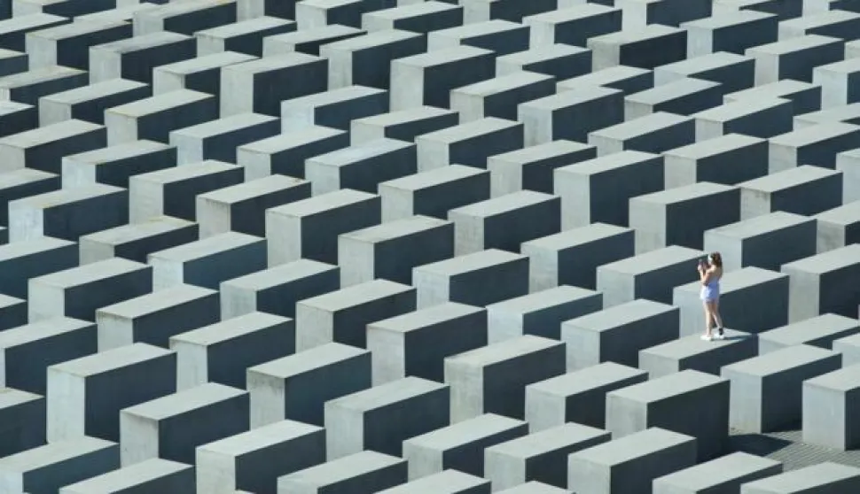 epa04874196 A visitor takes a picture as she stands on one of the concrete steles of the 'Memorial to the Murdered Jews of Europe', also known as the Holocaust Memorial, in&nbsp;Berlin, Germany, 06 August 2015. EPA/JOERG&nbsp;CARSTENSEN