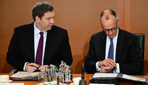 German Chancellor Friedrich Merz (R) and German Finance Minister and Vice Chancellor Lars Klingbeil talk at the start of the weekly cabinet meeting on January 28, 2026 at the Chancellery in Berlin. (Photo by Tobias SCHWARZ/AFP)