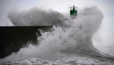 TOPSHOT - A big wave crashes against the pier at the port of A Guarda, northwestern Spain, on January 23, 2026. Depression Ingrid is expected to bring snow, torrential rain, and icy winds to Spain today as extreme weather and a sharp temperature drop are expected. (Photo by Miguel RIOPA/AFP)