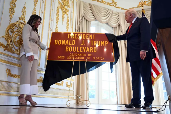 US President Donald Trump and Meg Weinberger (L), a Republican member of the Florida House of Representatives, unveil a road sign during a dedication ceremony for Southern Boulevard, in the ballroom at Mar-a-Lago in Palm Beach, Florida, on January 16, 2026. Palm Beach Southern Boulevard, between Kirk Road and South Ocean Boulevard, is being renamed as "President Donald J. Trump Boulevard." (Photo by ANDREW CABALLERO-REYNOLDS/AFP)