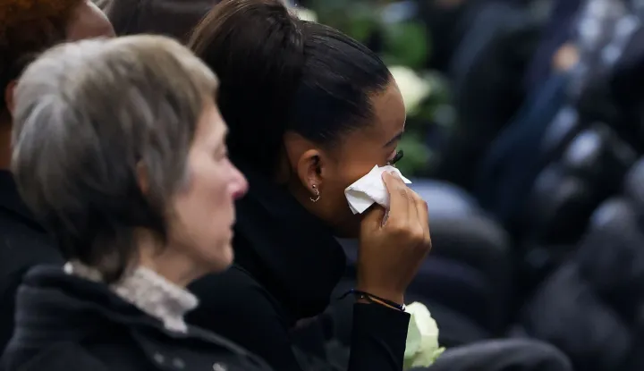 A mourner reacts during a tribute ceremony for the victims of the deadly fire that ripped through the bar Le Constellation in Crans-Montana on New Year's Eve, in Martigny, on January 9, 2026. All of Switzerland will mark a national day of mourning on January 9 for the dozens of mostly teenagers killed when fire ravaged a ski resort bar crammed with New Year revellers. Just over a week after the tragedy at the Le Constellation bar in Crans-Montana, which left 40 dead and 116 injured, the wealthy Alpine nation will come to a standstill for a minute of silence at 2:00 pm (1300 GMT). (Photo by Pierre Albouy/POOL/AFP)