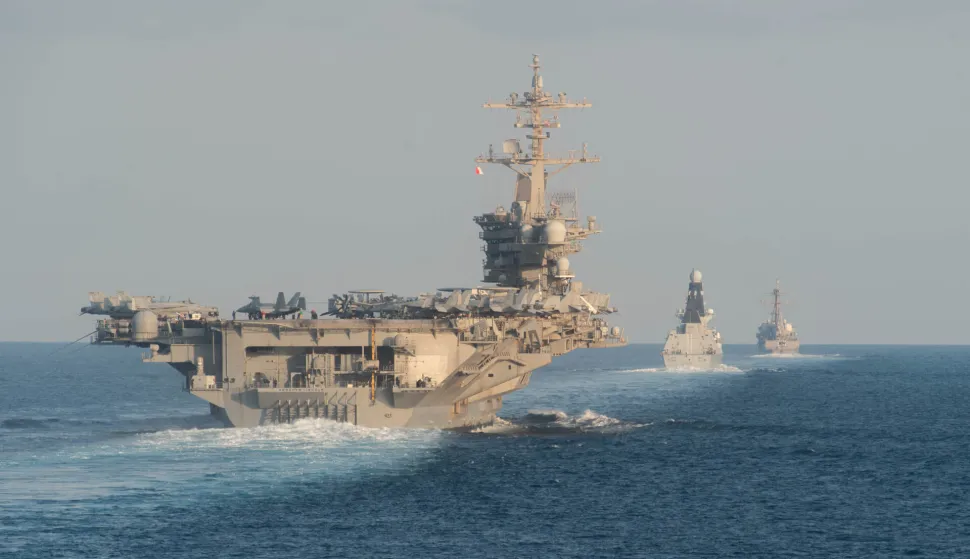 (FILES) The USS Abraham Lincoln aircraft carrier (L) transits the Strait of Hormuz on November 19, 2019. A US naval strike group led by the USS Abraham Lincoln aircraft carrier has deployed to Middle Eastern waters, the United States said on January 26, 2026, as Tehran warned it was ready to hit back at any American attack launched in response to a crackdown on anti-government protests. (Photo by Zachary PEARSON/US NAVY/AFP)/RESTRICTED TO EDITORIAL USE - MANDATORY CREDIT "AFP PHOTO/US Navy/Mass Communication Specialist 3rd Class Zachary Pearson" - NO MARKETING - NO ADVERTISING CAMPAIGNS - DISTRIBUTED AS A SERVICE TO CLIENTS