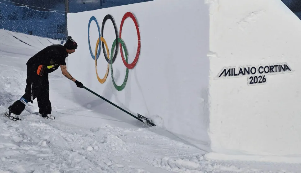 A worker shovels snow ahead of the snowboard men's big air qualifications during the Milano Cortina 2026 Winter Olympic Games at Livigno Snow Park, in Livigno (Valtellina), on February 4, 2026. (Photo by Jeff PACHOUD/AFP)